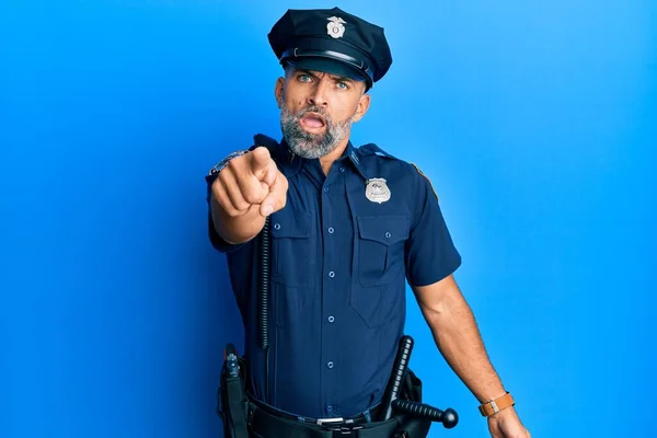 Middle age handsome man wearing police uniform pointing displeased and frustrated to the camera, angry and furious with you