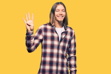 Yakışıklı, beyaz saçlı, hippi tişörtlü, dört numaralı parmaklarıyla kendini beğenmiş ve mutlu bir şekilde gülümseyen bir adam.. 