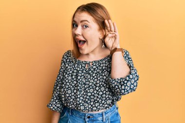 Çiçek desenli gömlek giyen genç, güzel, kızıl saçlı bir kadın. Kulağı kulağında gülümseyen ve dedikoduları ya da dedikoduları dinleyen. Sağırlık kavramı. 