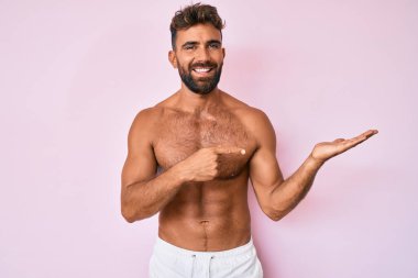 Latin asıllı genç adam kameraya hayret içinde bakıyor ve gülümsüyor.. 