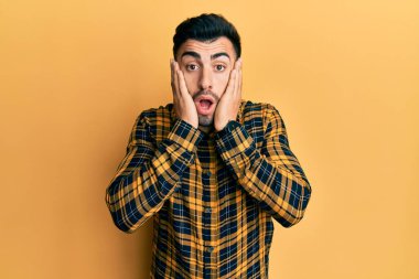 Günlük kıyafetler giyen genç İspanyol adam korkmuş ve şok olmuş, şaşırmış ve şaşırmış bir yüz ifadesi takınmıştı. 