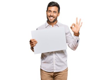 Yakışıklı İspanyol adam boş pankart tutuyor. Parmaklarıyla imza atıyor, gülümsüyor. Mükemmel bir sembol. 