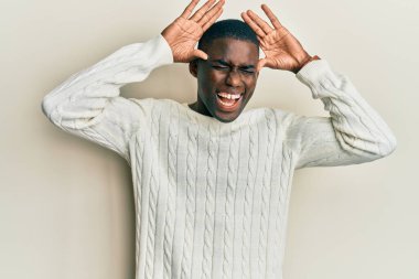 Genç Afro-Amerikalı günlük kıyafetler giymiş neşeli gülümseyen ve elleri havada bir böceği dikizleyen bir adam. Şaşırdım ve çıktım. 