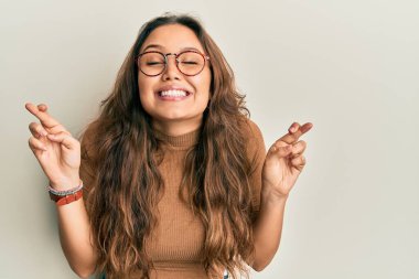 Gündelik kıyafetler giyen ve gözlüklü genç İspanyol kız umut ve gözlerin kapalı bir şekilde gülümseyerek bana işaret etti. Şans ve batıl inançlar. 