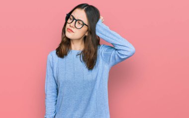 Gündelik kıyafet ve gözlük takan genç ve güzel bir kadın, soru sormayı ve kafa karıştırmayı sever. Şüpheyle kararsız, kafa kafaya düşünerek. Düşünceli kavram. 