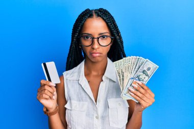 Elinde dolar ve kredi kartı olan güzel İspanyol bir kadın sıkıntılı ve endişeli, sinirli ve korkmuş bir şekilde ağlıyor. hüzünlü ifade. 