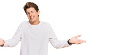 Yakışıklı, beyaz süveter giyen, neşeli gülümseyen, yardım eli uzatan ve kabul gören beyaz bir adam.. 