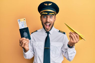 Yakışıklı İspanyol pilot elinde kağıt uçak ve pasaport tutarak çılgınlığı kutluyor ve şaşırıyor gözleri açık heyecanla bağırıyor.. 