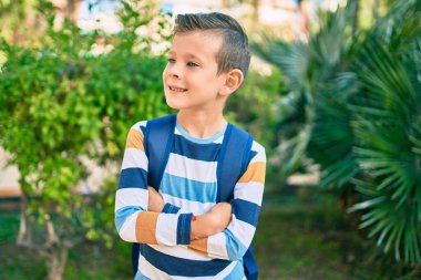 Kafkasyalı bir öğrenci parkta mutlu bir şekilde gülümsüyor..