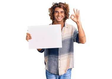 Genç İspanyol adam boş pankart tutuyor. Parmaklarıyla imza atıyor, gülümsüyor. Mükemmel bir sembol. 