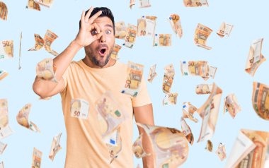 Gündelik kıyafetler giyen genç İspanyol adam şaşırmış yüz ifadesiyle şok olmuş, parmaklarından bakan gözler. İnançsız ifade.