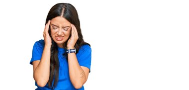 Güzel esmer, genç bir kadın. Elleri başının üstünde, gündelik kıyafetler giyiyor. Stres yüzünden baş ağrısı çekiyor. migren ağrısı. 