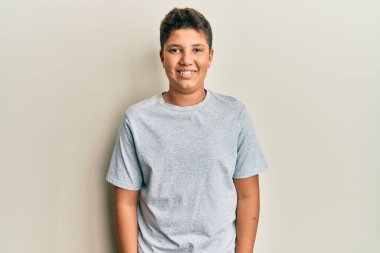 Teenager hispanic boy wearing casual grey t shirt with a happy and cool smile on face. lucky person. 