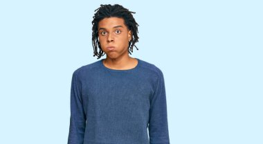 Sıradan bir kazak giyen genç Afro-Amerikan adam komik yüzlü yanakları şişiriyor. Havayla şişmiş ağız, çılgın bir ifade.. 