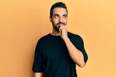 Gündelik kıyafetler giyen genç İspanyol adam şüphe üzerine yoğunlaşmıştı. Parmakları çenesinde ve yukarı bakıyordu. 