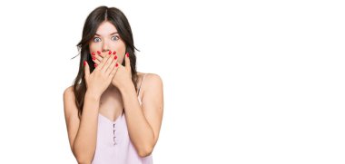 Gündelik giysiler giyen güzel beyaz bir kız yanlışlıkla elleri ile ağzını kapatırken şok oldu. gizli kavram. 