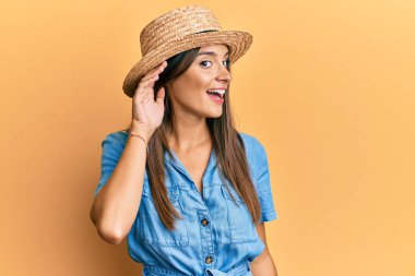 Yaz şapkası takan, ağzı kulaklarında gülümseyen, dedikodu ya da dedikoduları dinleyen genç İspanyol kadın. Sağırlık kavramı. 
