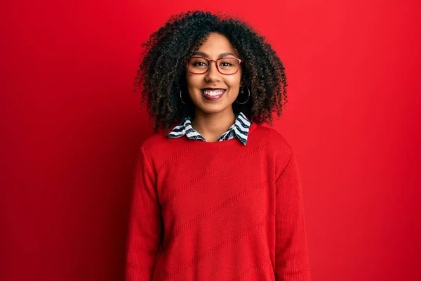 Beautiful african american woman with afro hair wearing sweater and glasses with a happy and cool smile on face. lucky person.
