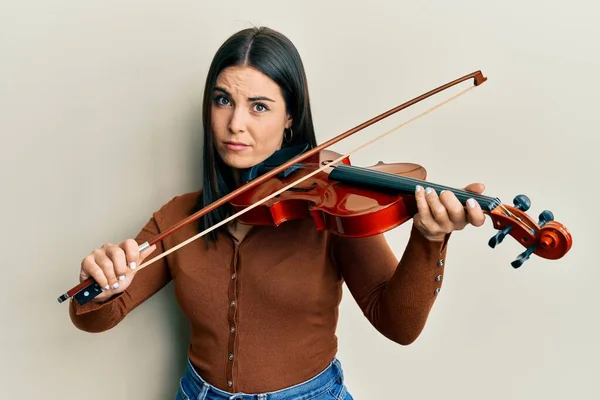 Jovem Morena Tocando Violino Cético Nervoso Franzindo Testa Por Causa — Fotografia de Stock