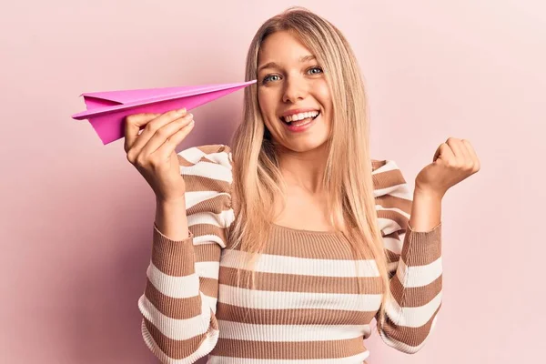 Jovem Loira Segurando Avião Papel Gritando Orgulhoso Celebrando Vitória Sucesso — Fotografia de Stock