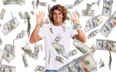 Gündelik beyaz tişört giyen genç İspanyol adam dokuz numarayı gösterip işaret ederken kendinden emin ve mutlu bir şekilde gülümsüyor..