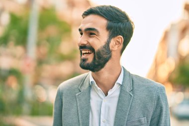 Genç İspanyol işadamı gülümseyerek şehirde mutlu mesut duruyor..