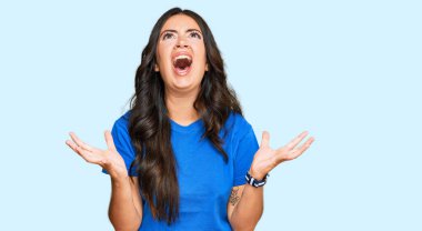 Güzel esmer, sıradan kıyafetler giyen çılgın, deli gibi bağıran, agresif ifadeli ve kollarını kaldırmış genç bir kadın. hüsran kavramı. 