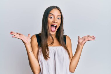 Gündelik kıyafetler giyen genç İspanyol kadın zaferi mutlu bir gülümsemeyle ve kazanan ifadeyle kutluyor. 