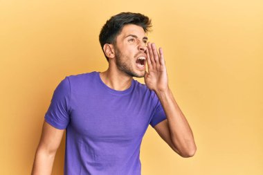 Sıradan kıyafetler giyen genç yakışıklı adam el ele verip bağırarak ve yüksek sesle bağırıyor. iletişim konsepti. 