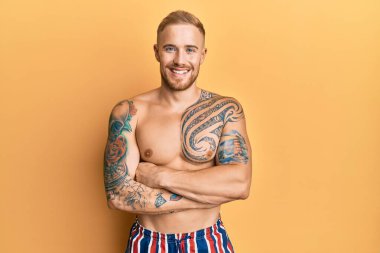 Mayo giyen, kolları çapraz gülümseyen beyaz bir adam kameraya bakıyordu. pozitif kişi. 