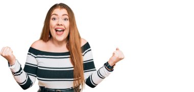 Zarif giysiler giymiş genç ve güzel bir kızıl kadın kollarını kaldırıp, gözlerini açarak başarının şokunu yaşıyor. Kazanan konsept. 