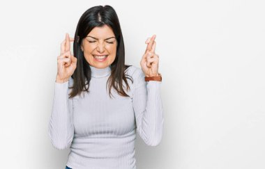 Güzel esmer kadın sıradan kıyafetler giyip umut ve gözlerin kapalı bir şekilde gülümseyerek el sallıyor. Şans ve batıl inançlar. 