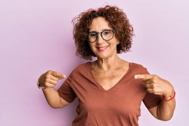 Güzel, orta yaşlı, normal kıyafetler ve gözlük takan, kendine güvenen, gülümseyen, kendini gururlu ve mutlu gösteren olgun bir kadın.. 