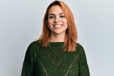 Yüzünde mutlu ve havalı bir gülümseme olan sıradan bir kazak giyen İspanyol genç kadın. şanslı kişi. 