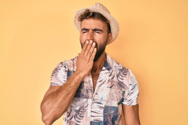 Yaz şapkası takan İspanyol genç adam ağzıyla esnemekten sıkıldı. Huzursuz ve uykulu.. 