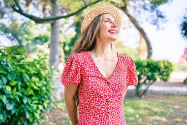 Genç sarışın kadın tatilde. Gülümsüyor. Parkta mutlu yürüyüşler.