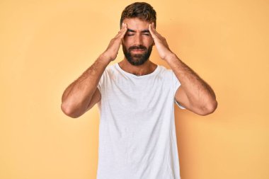 İspanyol asıllı genç adam gündelik giysiler giyiyor. Baş ağrısı çekiyor. Acı ve migren yüzünden çaresiz ve stresli. Eller başının üstünde.. 