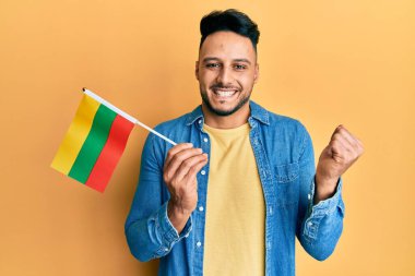 Elinde Litvanya bayrağı tutan genç Arap adam gururla haykırıyor, zaferi ve başarıyı kutluyor. 