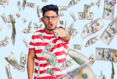 Yakışıklı Latin Amerikalı sıradan kıyafetler ve gözlük takan genç adam kameraya kızgın ve sinirli olduğunu gösteriyor.