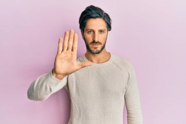 Günlük kışlık kazak giyen İspanyol genç adam avucunun içi gibi şarkı söylemeyi kesiyor. Yüzünde olumsuz ve ciddi bir jest olan uyarı ifadesi. 