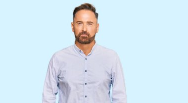 Yakışıklı, orta yaşlı, iş gömleği giyen şüpheci ve gergin, sorun yüzünden surat asan bir adam. negatif kişi. 