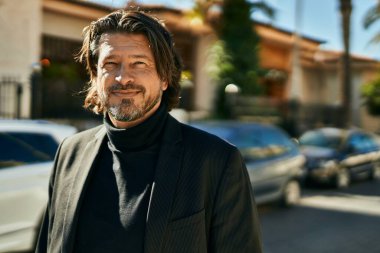 Orta yaşlı işadamı şehirde mutlu mesut dikilirken.