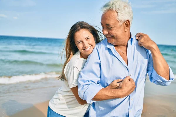 Middle Age Hispanic Couple Smiling Happy Hugging Walking Beach