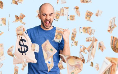 Elinde dolar sembolü olan genç yakışıklı adam gururla bağırıyor zaferi ve başarıyı kutluyor.