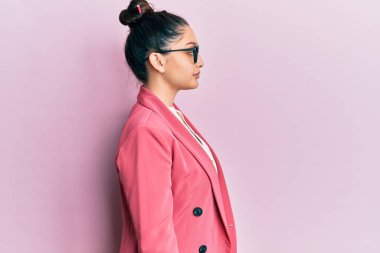 İş ceketi ve gözlük takan güzel bir ortadoğulu kadın rahat bir görünüm ve kendine güvenen bir gülümseme takınıyor.. 