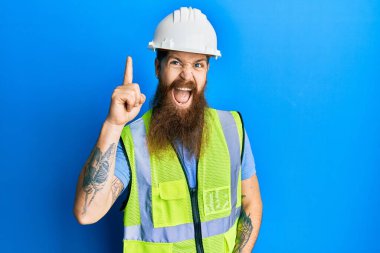 Uzun sakallı, güvenlik kaskı takan ve parlak ceketli, parlak fikirli kızıl saçlı bir adam. Heyecanlı ve mutlu. Bir numara.. 