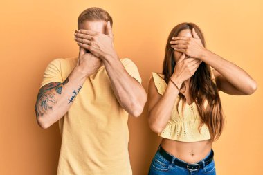 Genç bir çift kız arkadaş ve erkek arkadaş birbirlerine sarılıyor ve birlikte duruyorlar gözleri ve ağızları kapatıyorlar, şaşırmış ve şok olmuşlar. duygu gizleme 