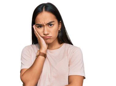 Genç Asyalı kadın günlük kıyafetler giyip kollarını kavuşturarak depresyondan sıkılmış ve yorgun görünüyor.. 