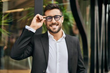 Genç İspanyol işadamı gülümseyerek şehirde mutlu mesut duruyor..