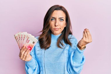 Genç esmer kadın elinde 20 İsrail şekeri banknotları tutuyordu. İtalyan jestleri yapıyordu. Elleri ve parmakları kendinden emindi. 